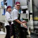 Chefs in red hats and aprons working in La Baldigara kitchen